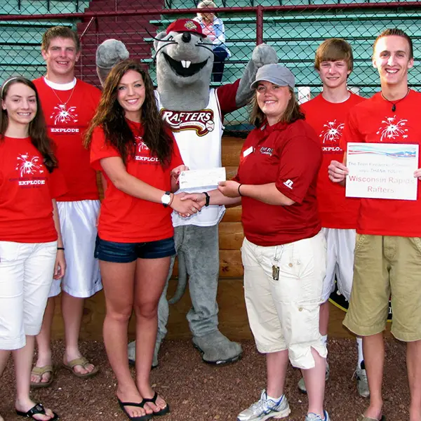 Teens with Mascot, holding a check and certificate