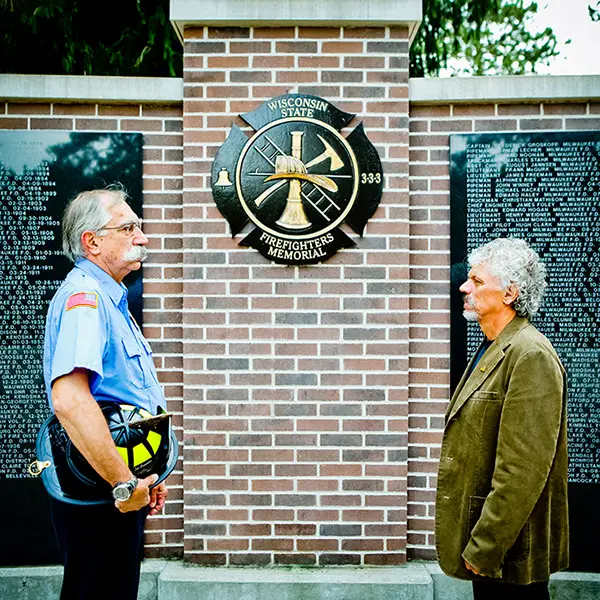 Two men standing at Fireman's memorial