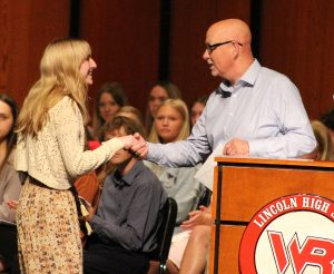 Man shakes hand of female student