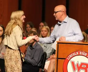 Man shakes hand of female student