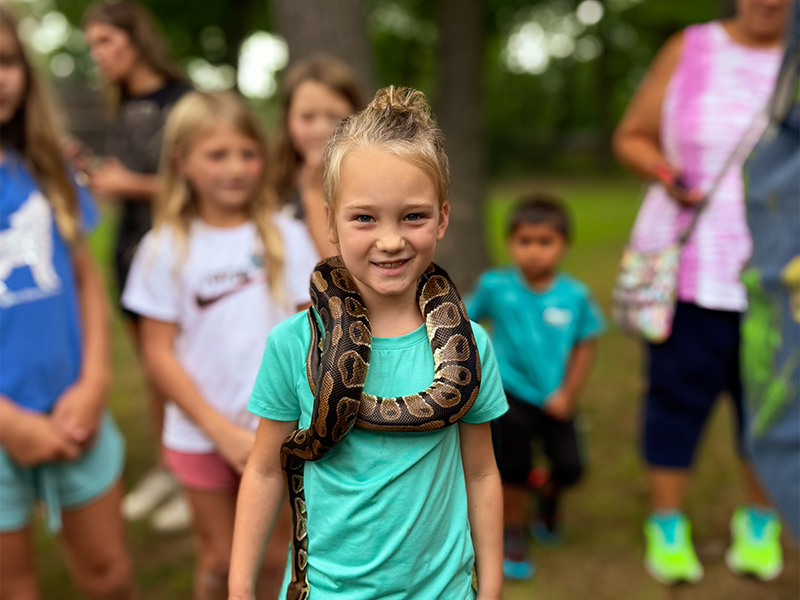 Girl with pet snake around her neck