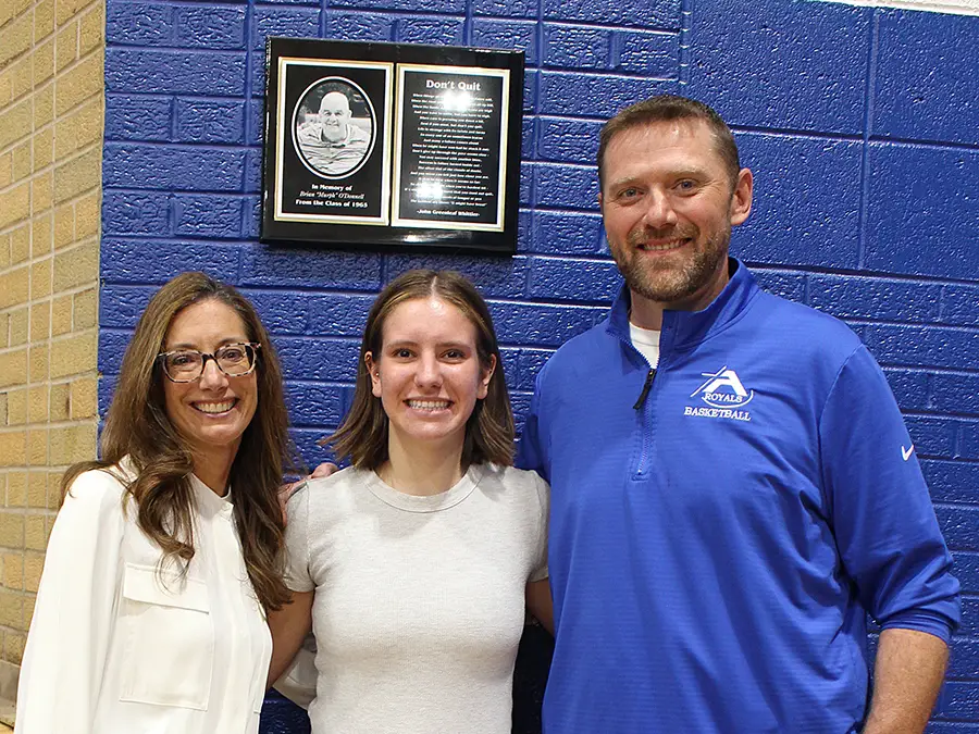 Student and two adults smiling